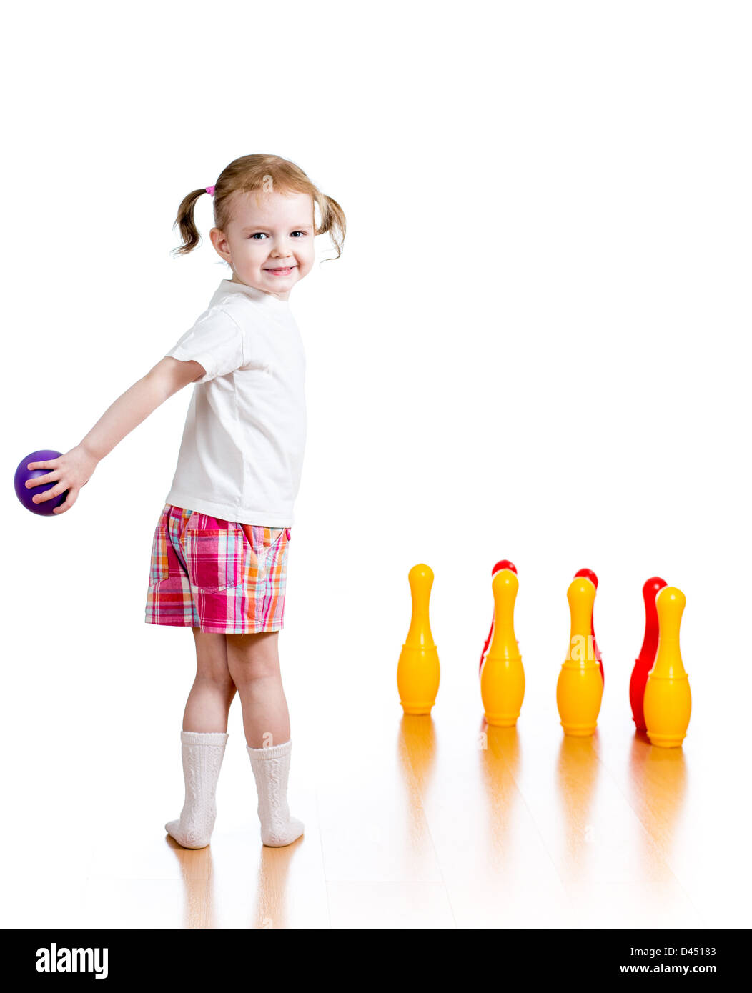 Kind Mädchen wirft Ball Spielzeug bowling-Pins abzureißen. Kind im Mittelpunkt. Stockfoto