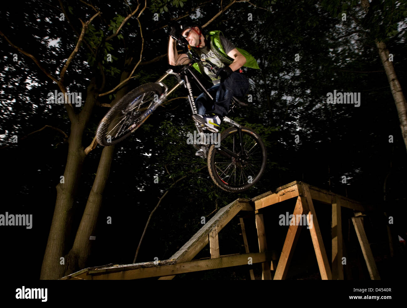 Mountain Bike Ramp Stunt Action, Esher Wald, England Stockfoto