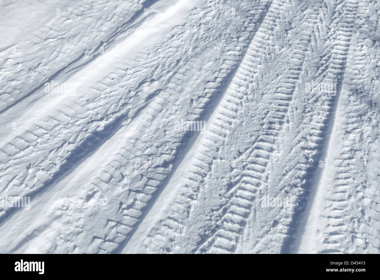 Hintergrundtextur des Reifens Bahnen auf der Straße mit Schnee bedeckt Stockfoto