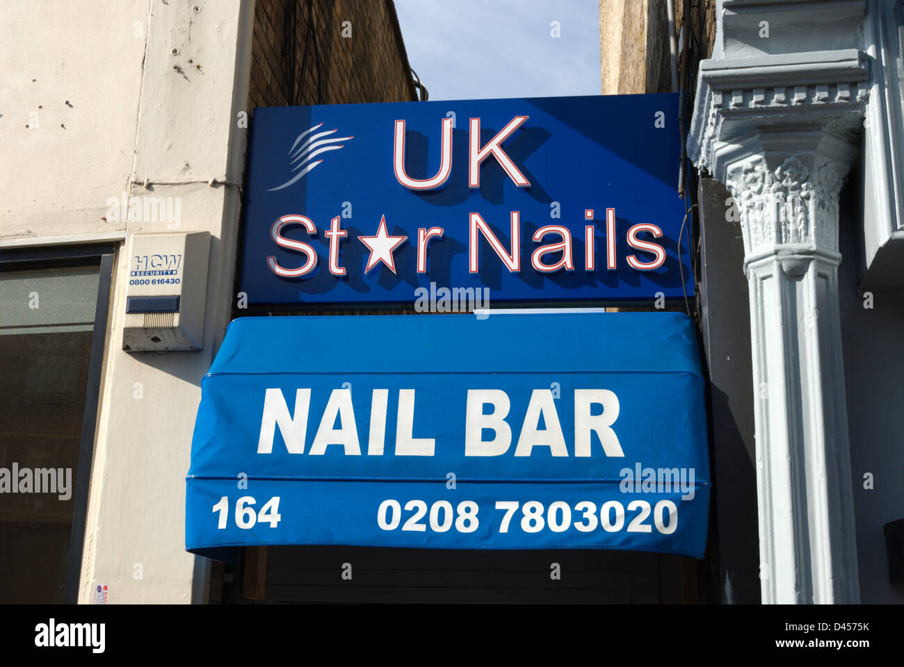 Zeichen und Markise für ein Nagelstudio oder Manicuirsts, eingezwängt in eine Lücke zwischen den Gebäuden in Putney, Südwesten von London, england Stockfoto