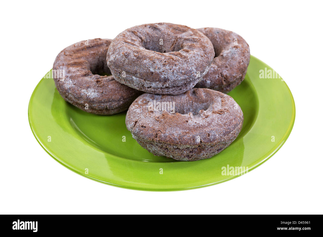 Eine kleine grüne Platte mit vier frischen Schokoladen Donuts auf weißem Hintergrund. Stockfoto