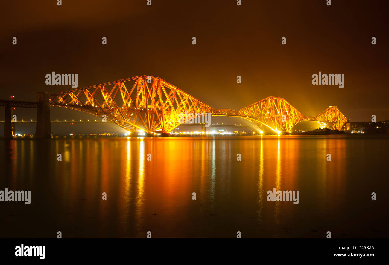 Die Forth Rail Bridge bei Nacht und voll beleuchtet mit der Forth Road ...