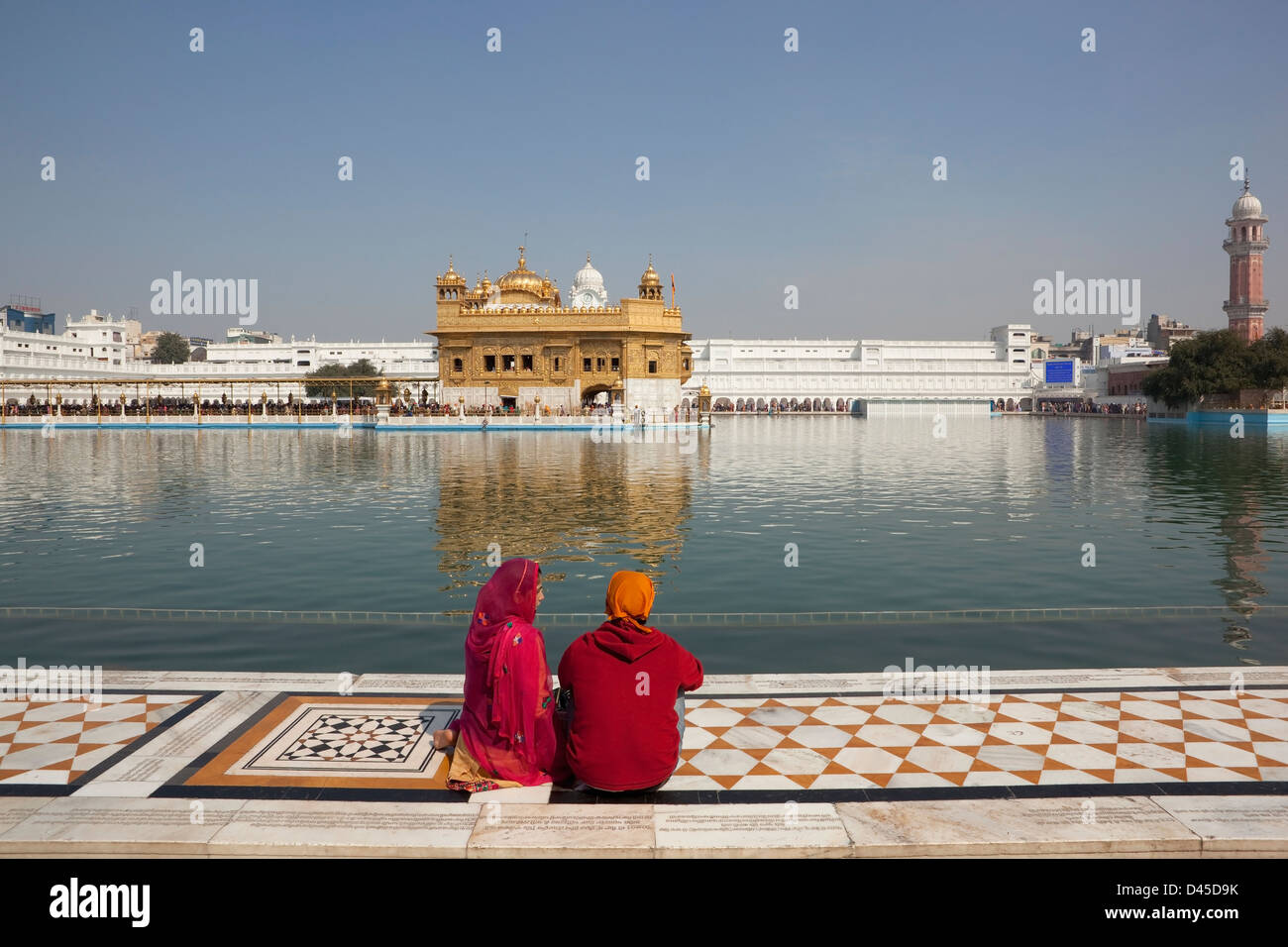 Ein junges Sikh paar sitzen vor dem Haramandir Sahib in den Golden Tempel Komplex, Amritsar, Punjab, Indien Stockfoto