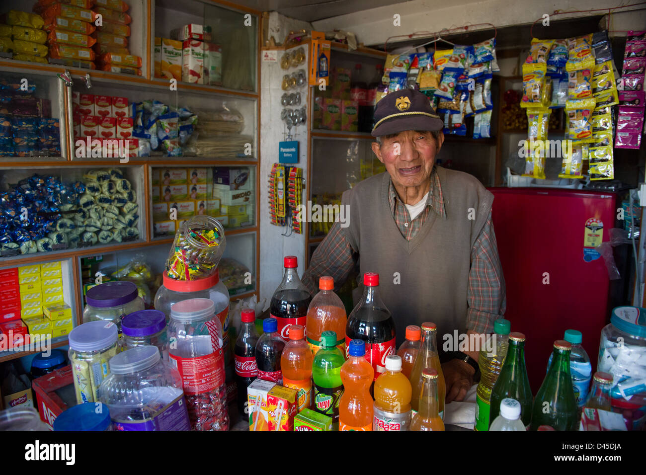 Ältere männliche Ladenbesitzer in einem kleinen Lebensmittelladen in der Altstadt, Leh (Ladakh) Jammu & Kaschmir, Indien Stockfoto