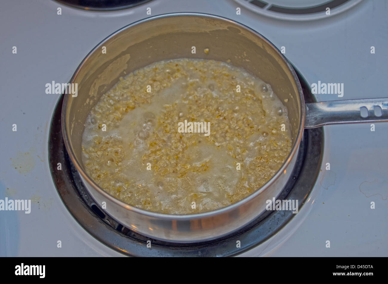 HAFERFLOCKEN KOCHEN AUF DEM HERD Stockfoto