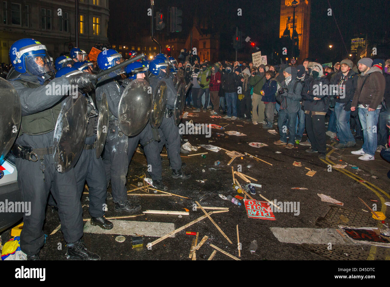 Polizei-Linie in voller Kampfausrüstung konfrontiert durch protestierende Studenten am Ende von Whitehall bei Nacht, Tag X3 Studentendemonstration, London, England Stockfoto