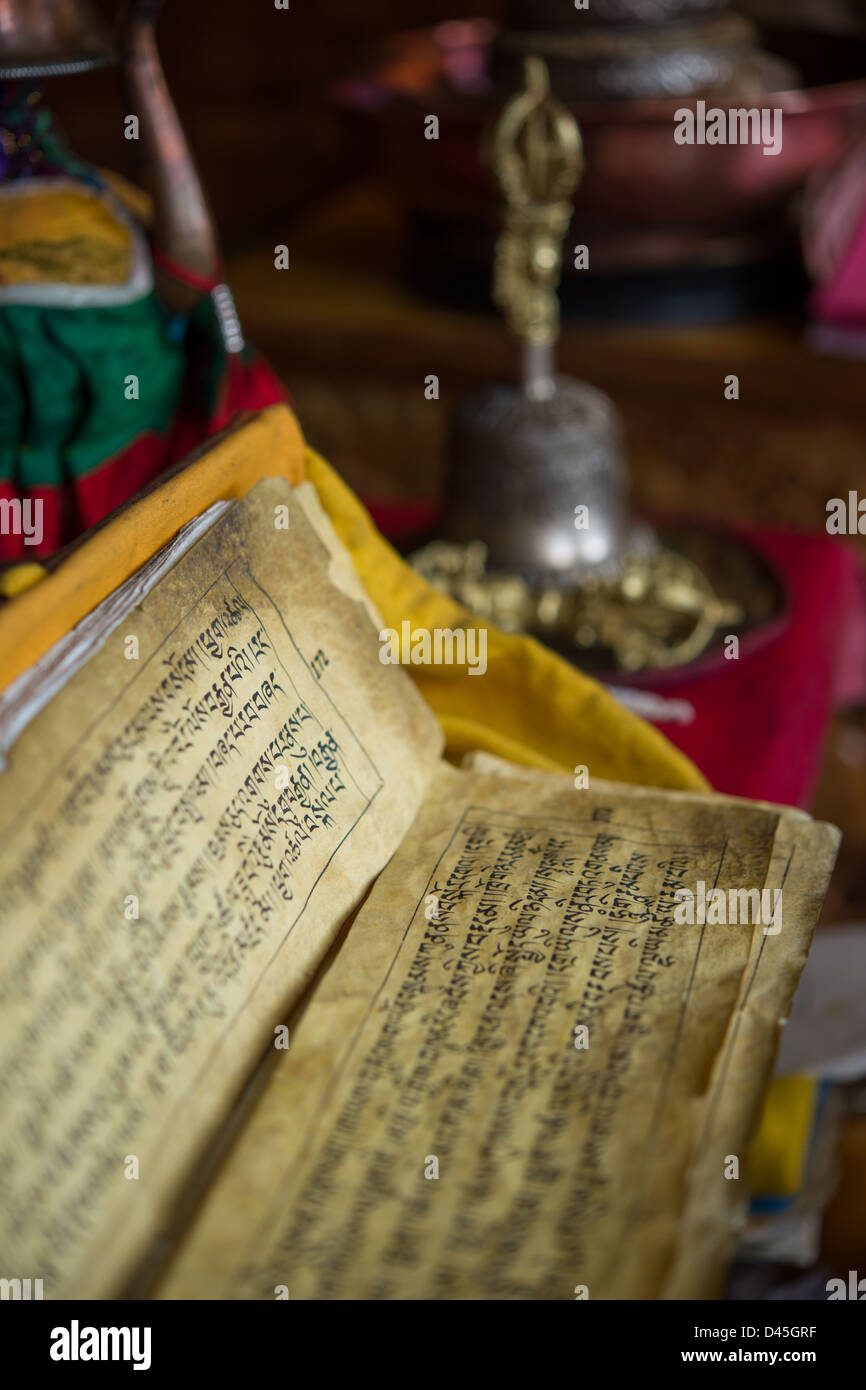 Gebetbuch in tibetischer Schrift, mit Hand-Glocke hinter Spituk Gompa, Leh (Ladakh) Jammu & Kaschmir, Indien Stockfoto