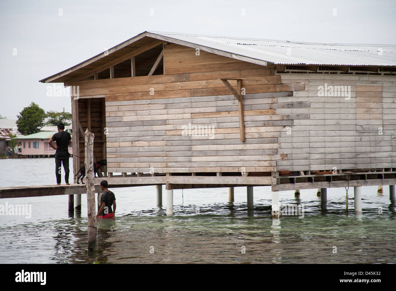 Zwei Panamanians durch ein Haus auf Stelzen im Wasser des Meeres stehen. Stockfoto