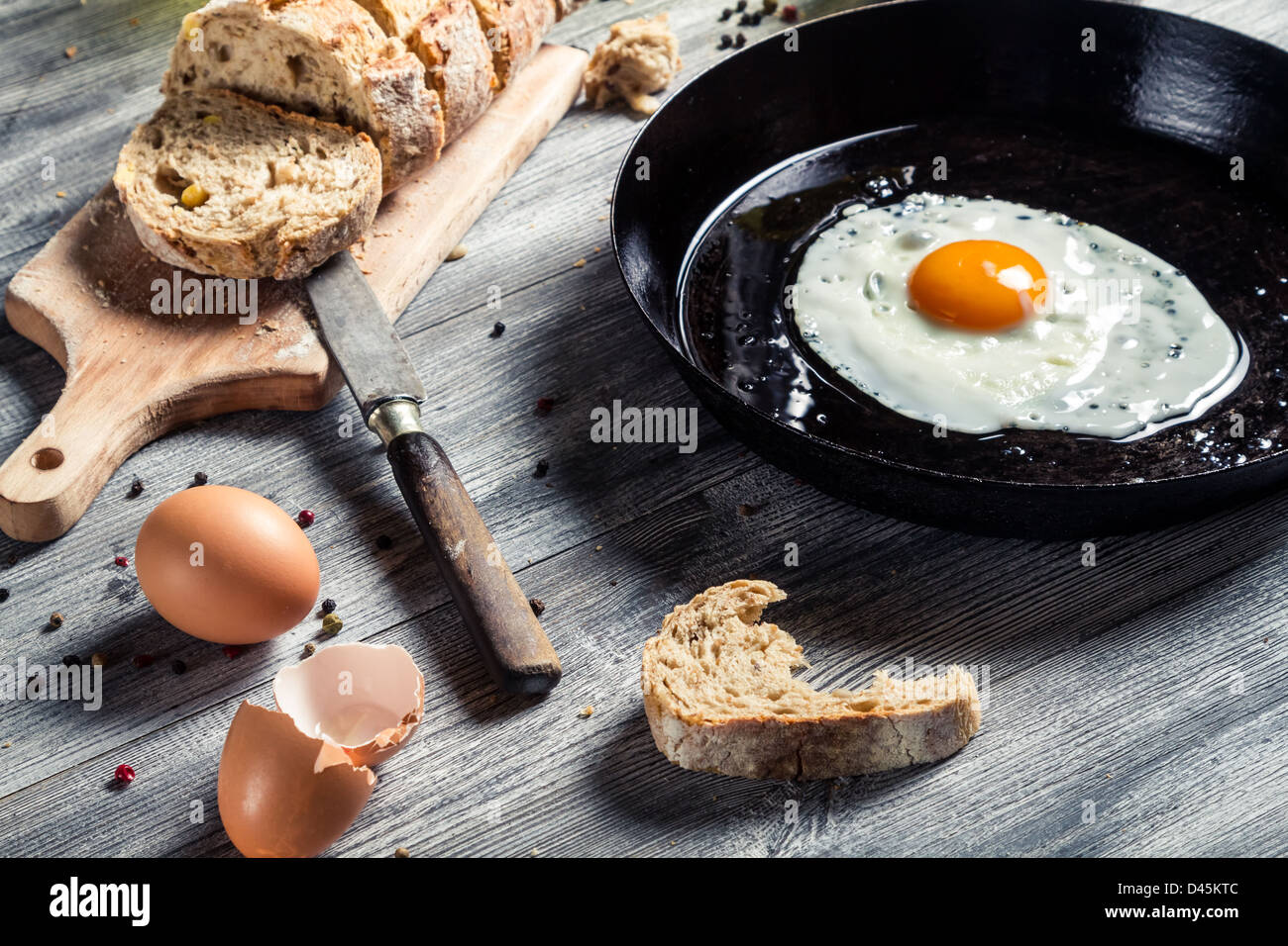 Gebratenes Ei auf einer Pfanne und mit Brot serviert Stockfoto