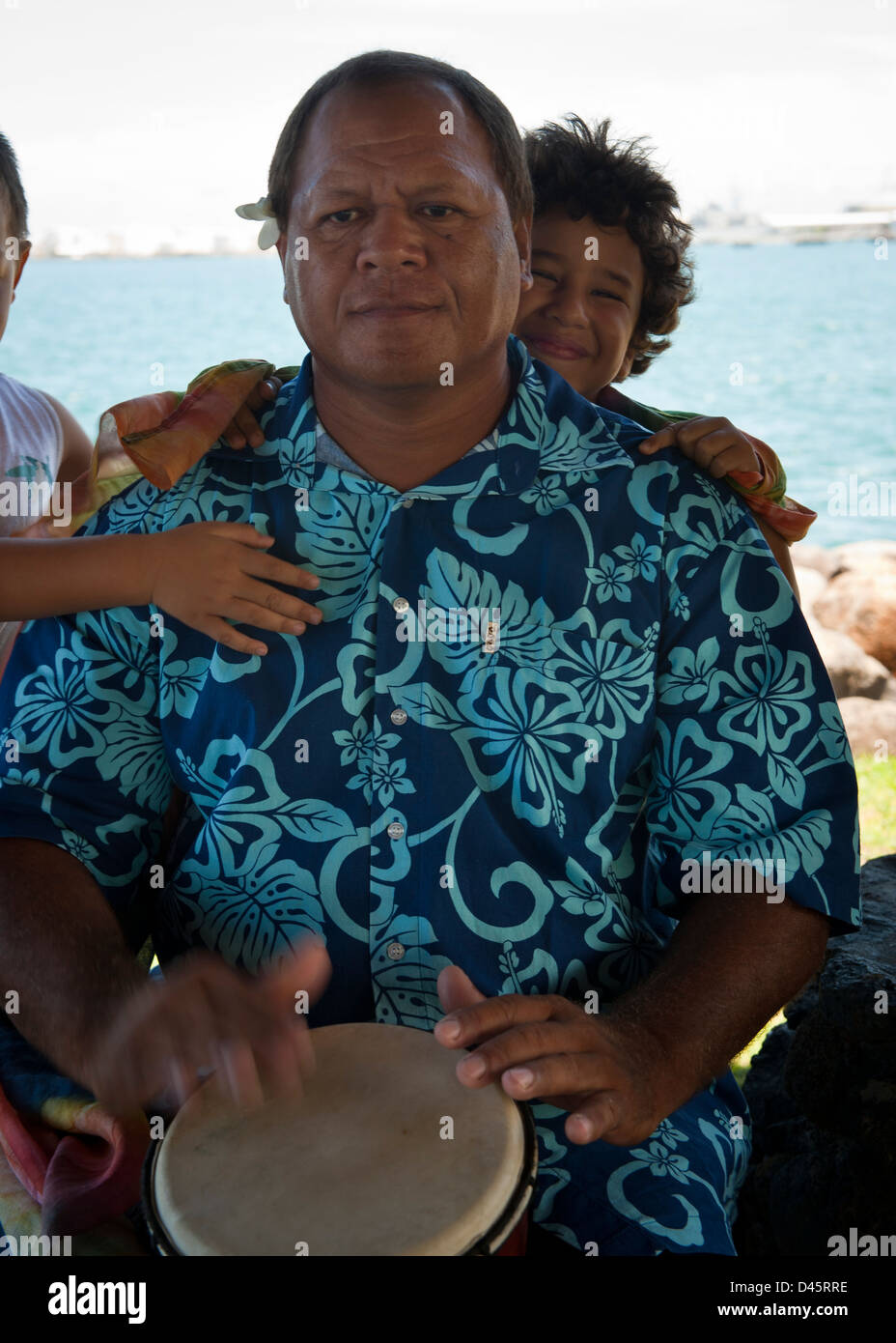 Polynesische Mann in floral Shirt mit Kindern, spielt Bongo Trommel, Papeete Stockfoto