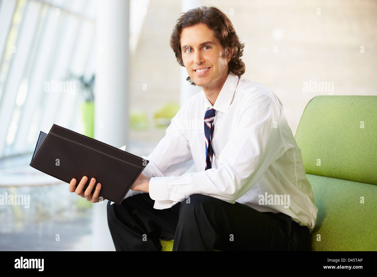 Porträt der Geschäftsmann sitzt auf dem Sofa lesen Bericht Stockfoto