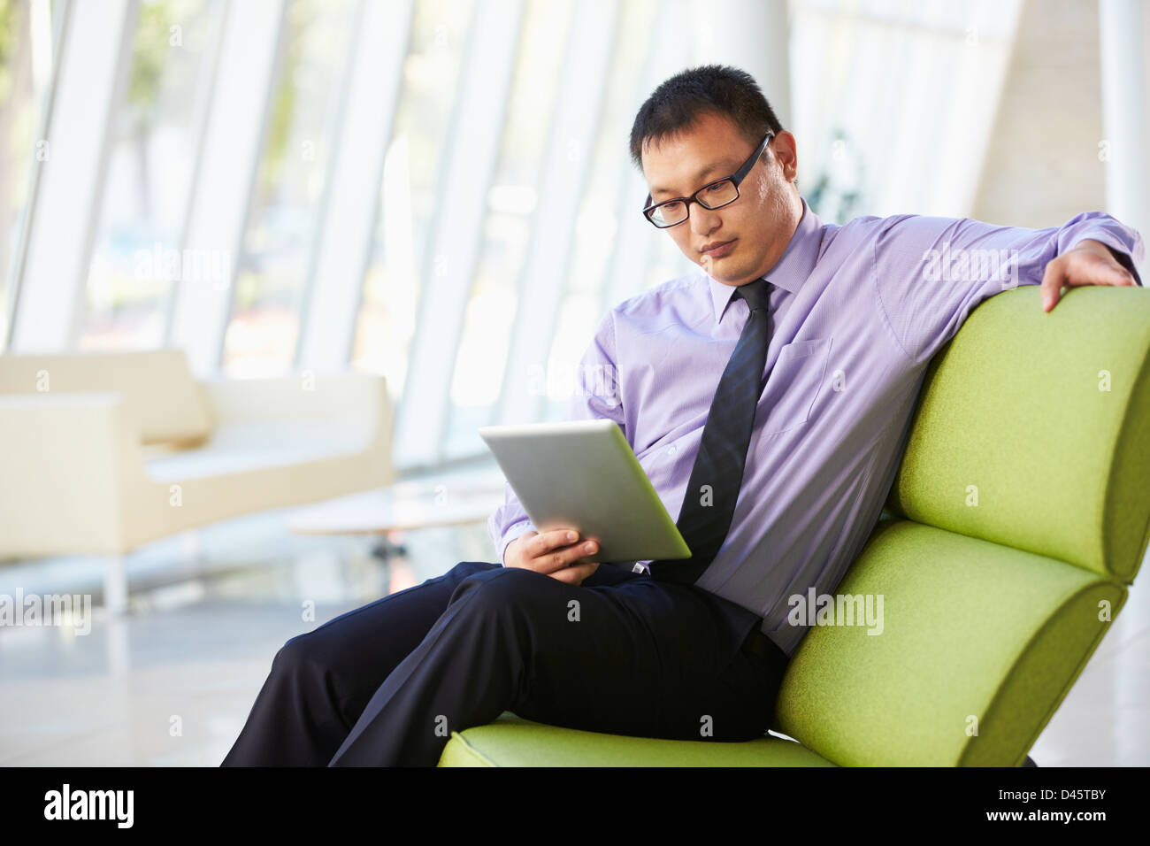 Geschäftsmann, sitzen im modernen Büro mit Digital-Tablette Stockfoto