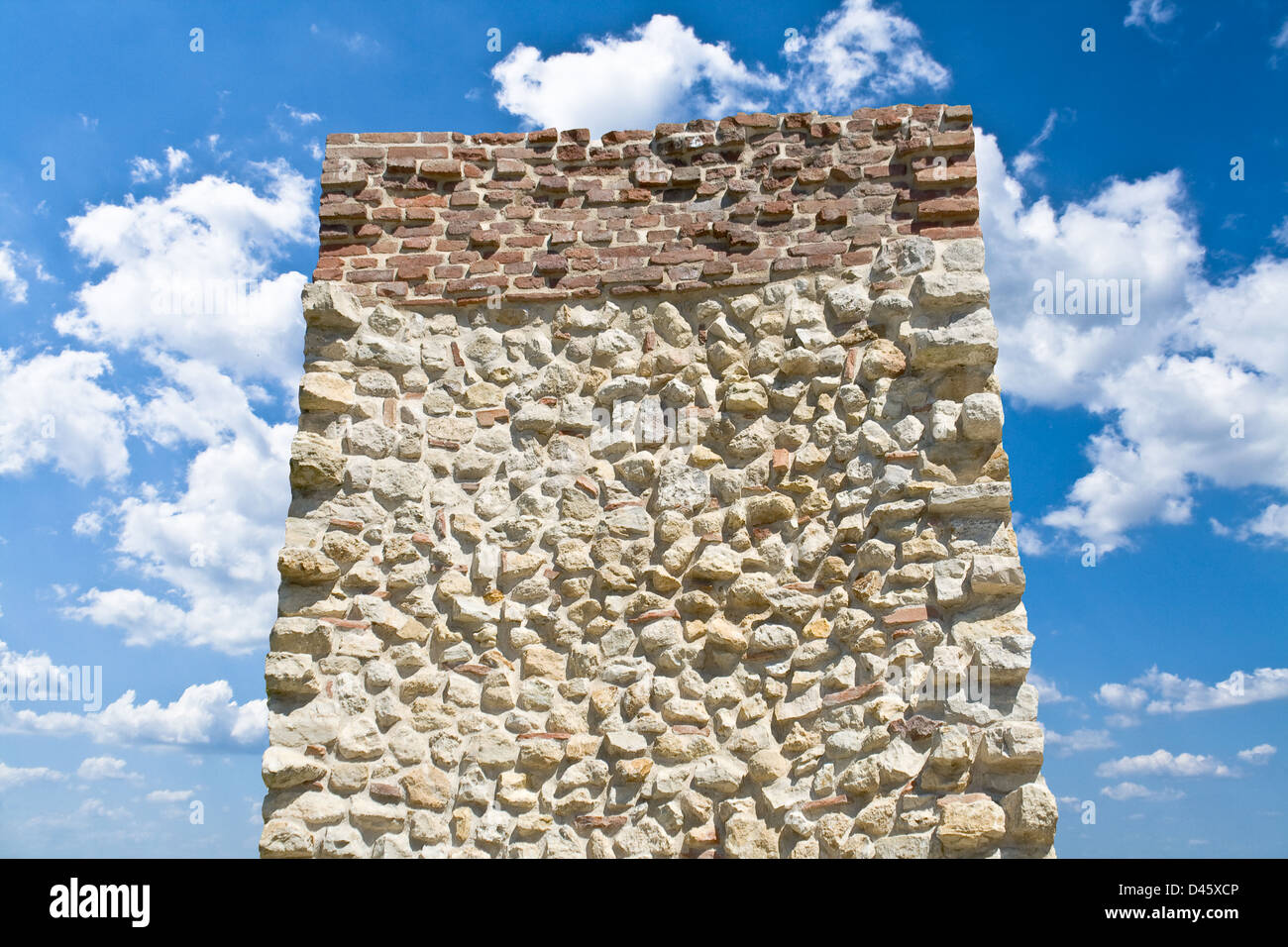 Stein-Monolith über blauer Himmel mit weißen Wolken Stockfoto