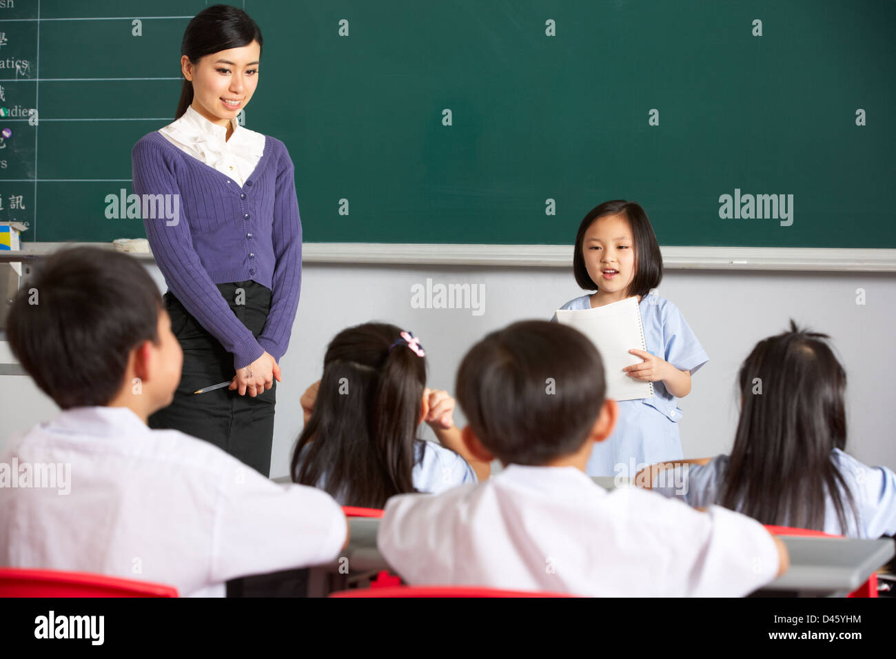 Schüler und Lehrer von Blackboard In Chinesisch Schulklasse stehend Stockfoto