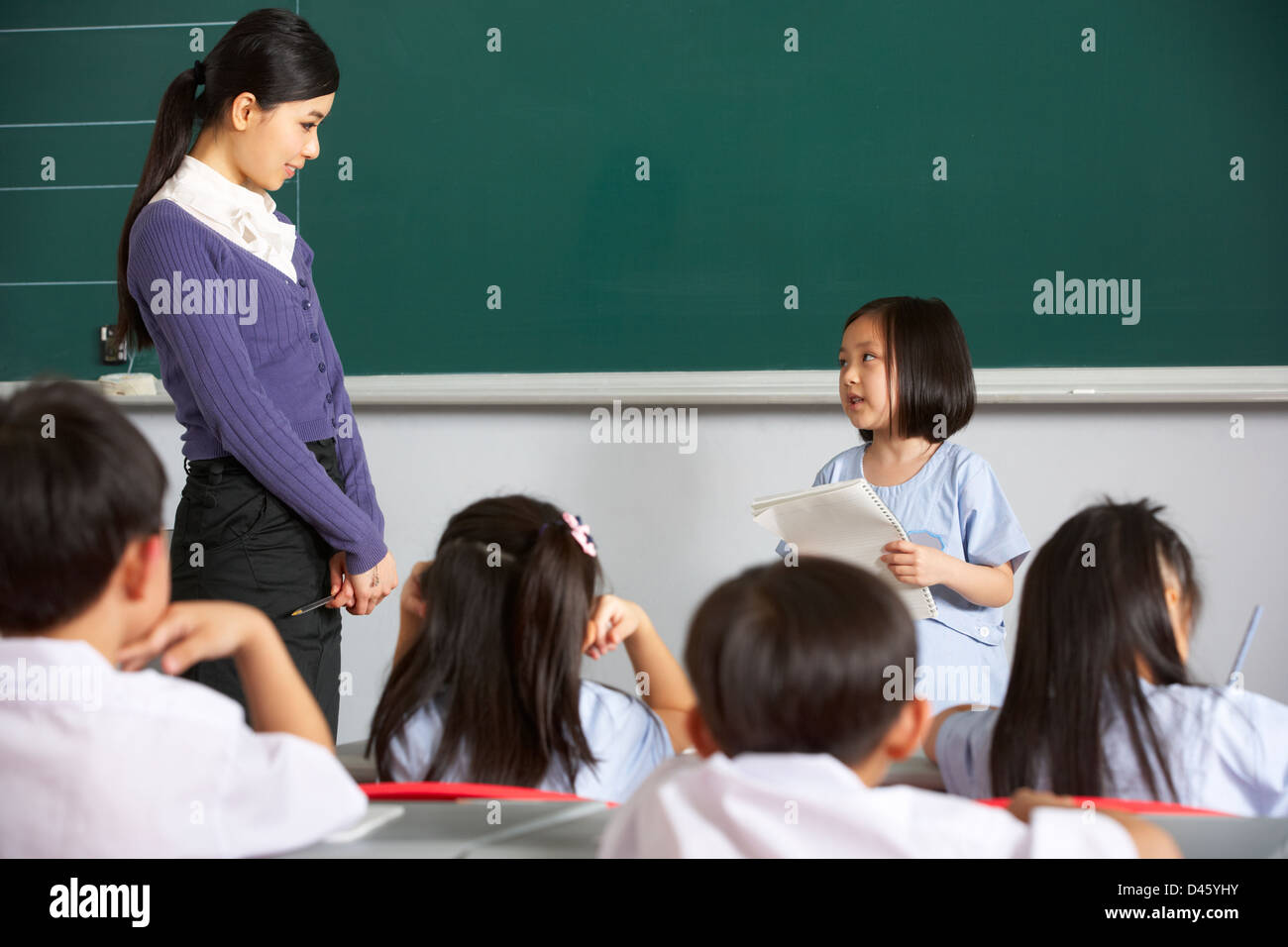 Schüler und Lehrer von Blackboard In Chinesisch Schulklasse stehend Stockfoto