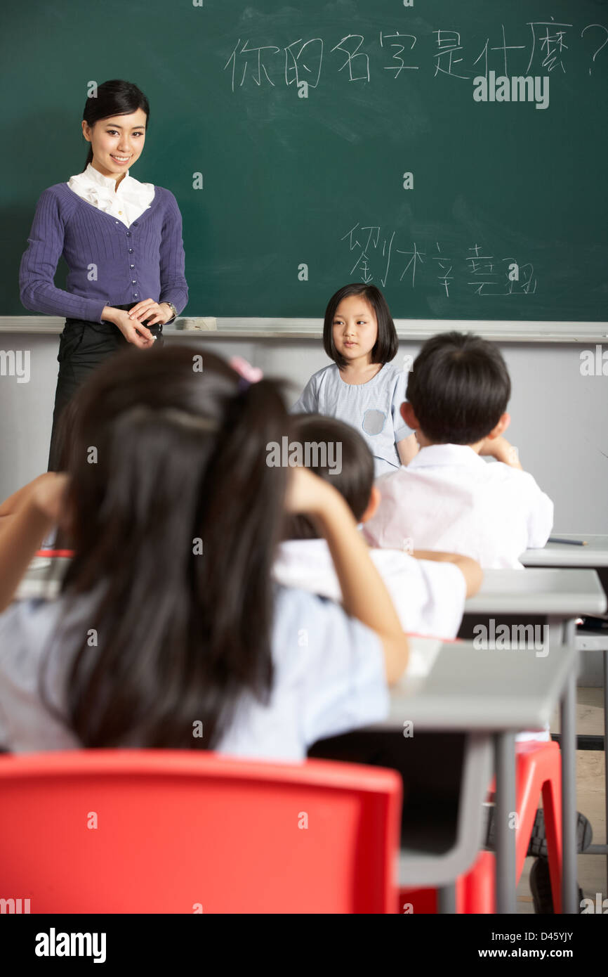 Schüler und Lehrer von Blackboard In Chinesisch Schulklasse stehend Stockfoto