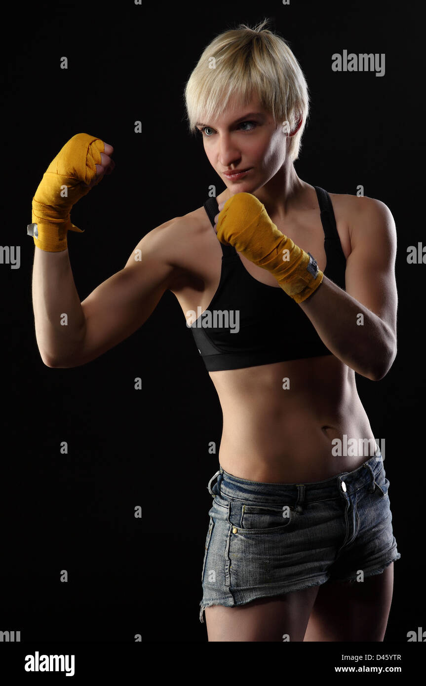 junge Frau auf schwarzem Hintergrund in dramatische Beleuchtung Boxen Stockfoto