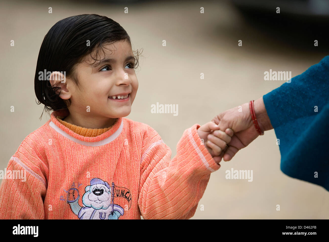 Mädchen, die ihre Mütter Hand haltend Stockfoto