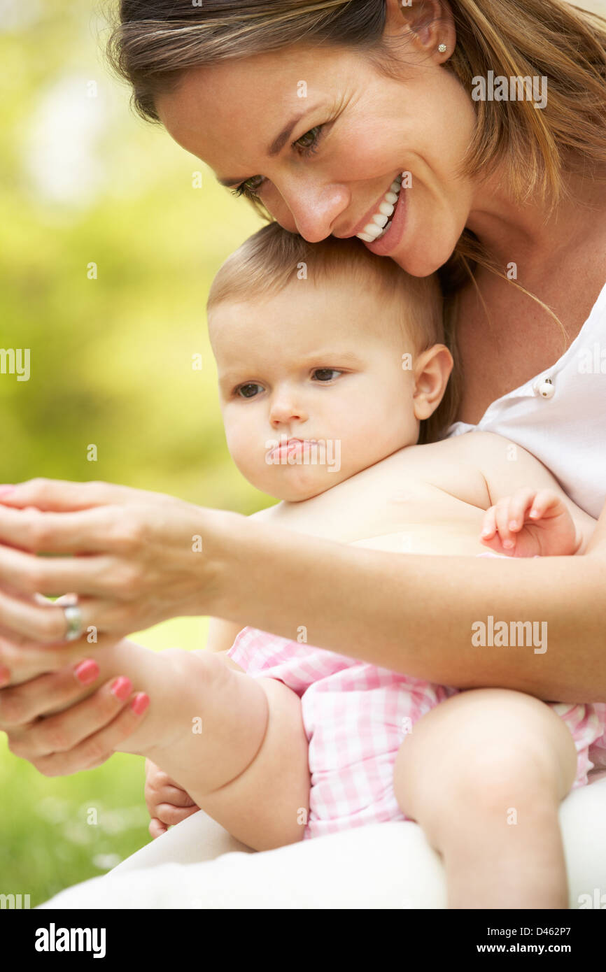 Mutter mit Babymädchen im Bereich der Sommerblumen Stockfoto