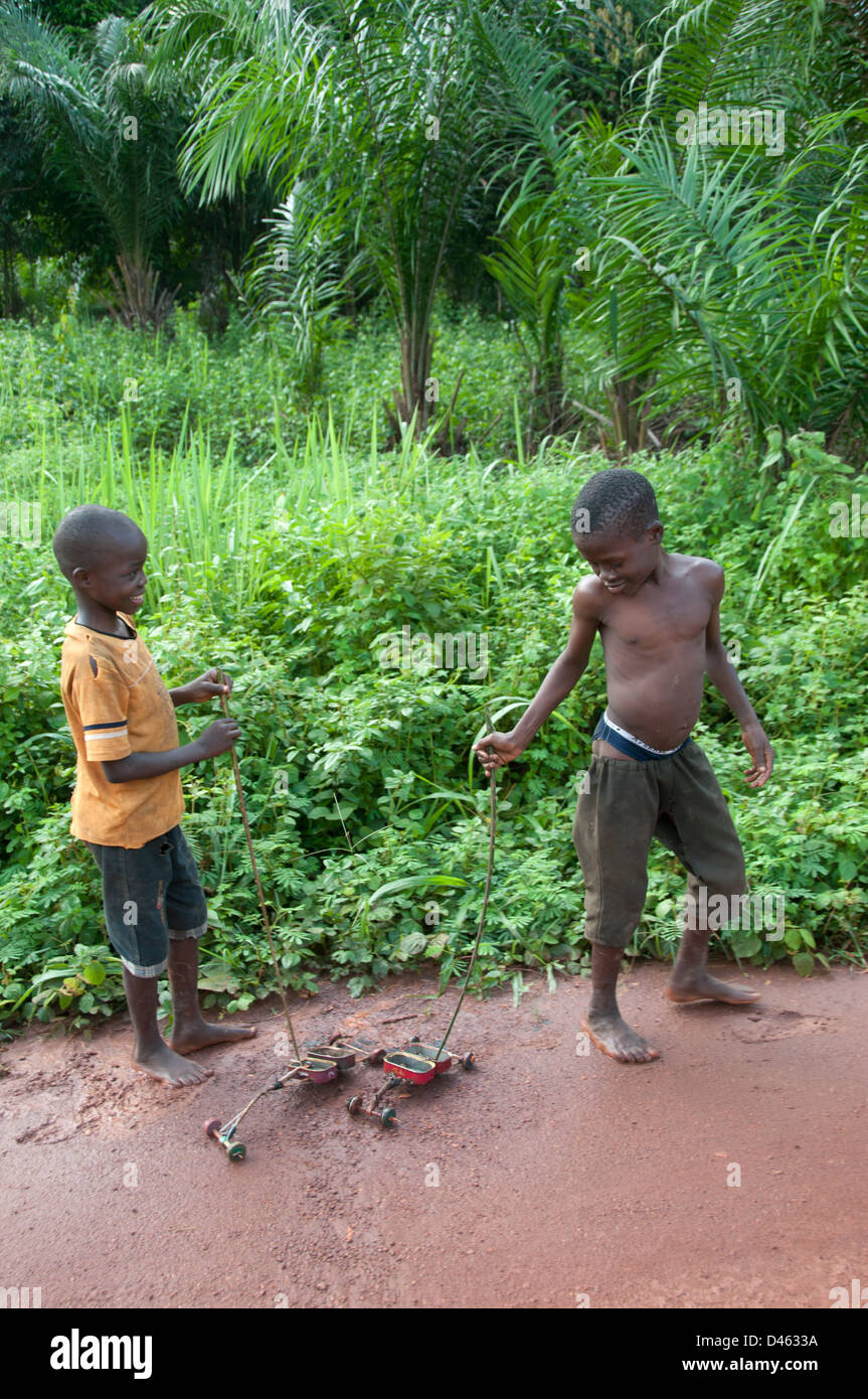 Zentralafrikanische Republik. August 2012. Batalimo. Zwei jungen mit selbst gebastelten Spielzeugautos aus Sardinen Dosen gemacht Stockfoto