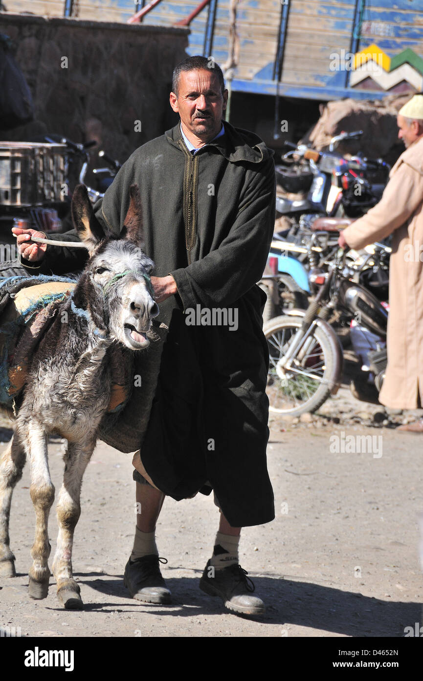 Marokkanischen Mann mit einem djellaba mit seinem Esel auf dem Markt cay am Jemaa D'Rehmat, südlich von Marrakesch, Marokko Stockfoto