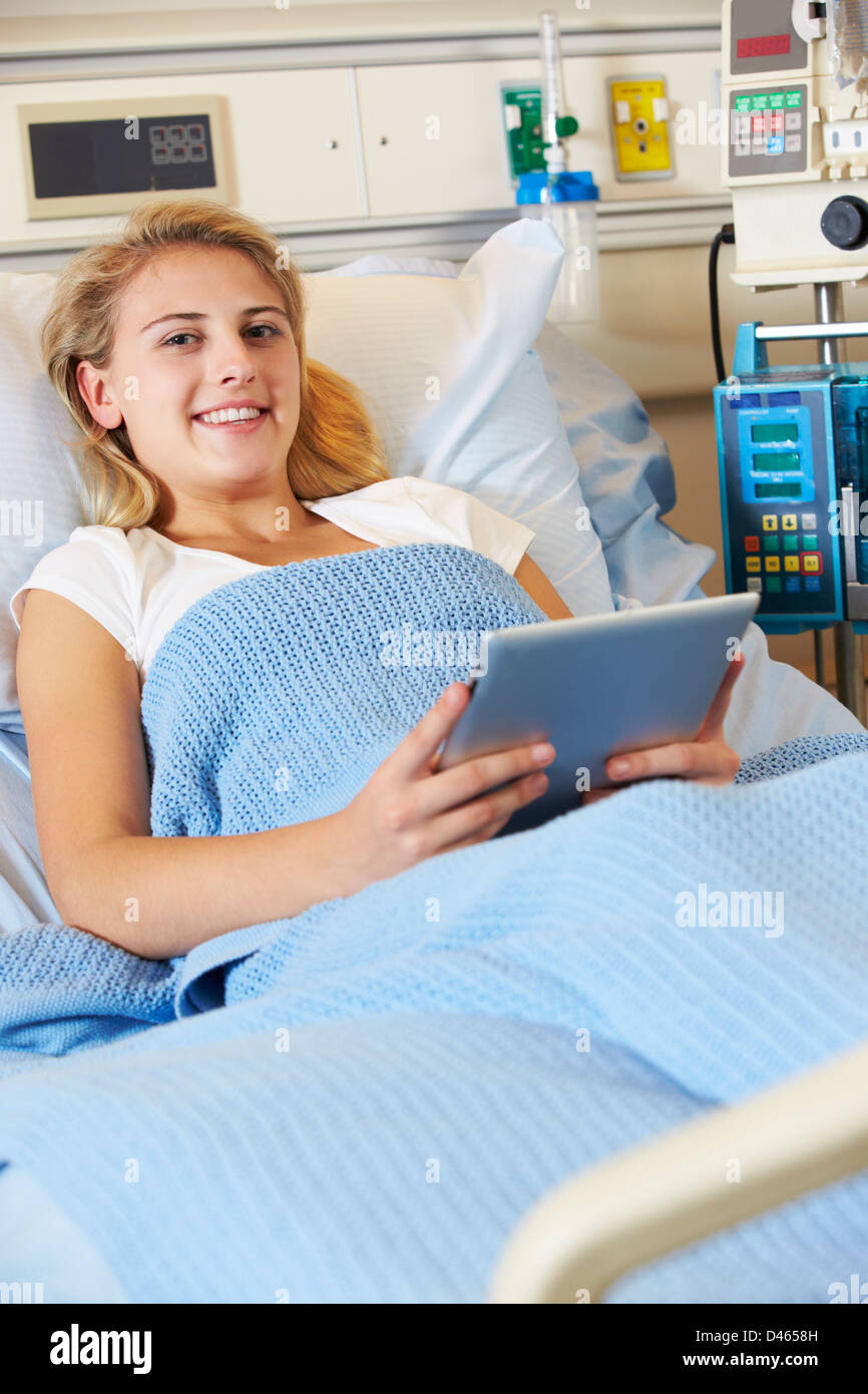 Teenager Patientin entspannend im Krankenhausbett mit Digital-Tablette Stockfoto