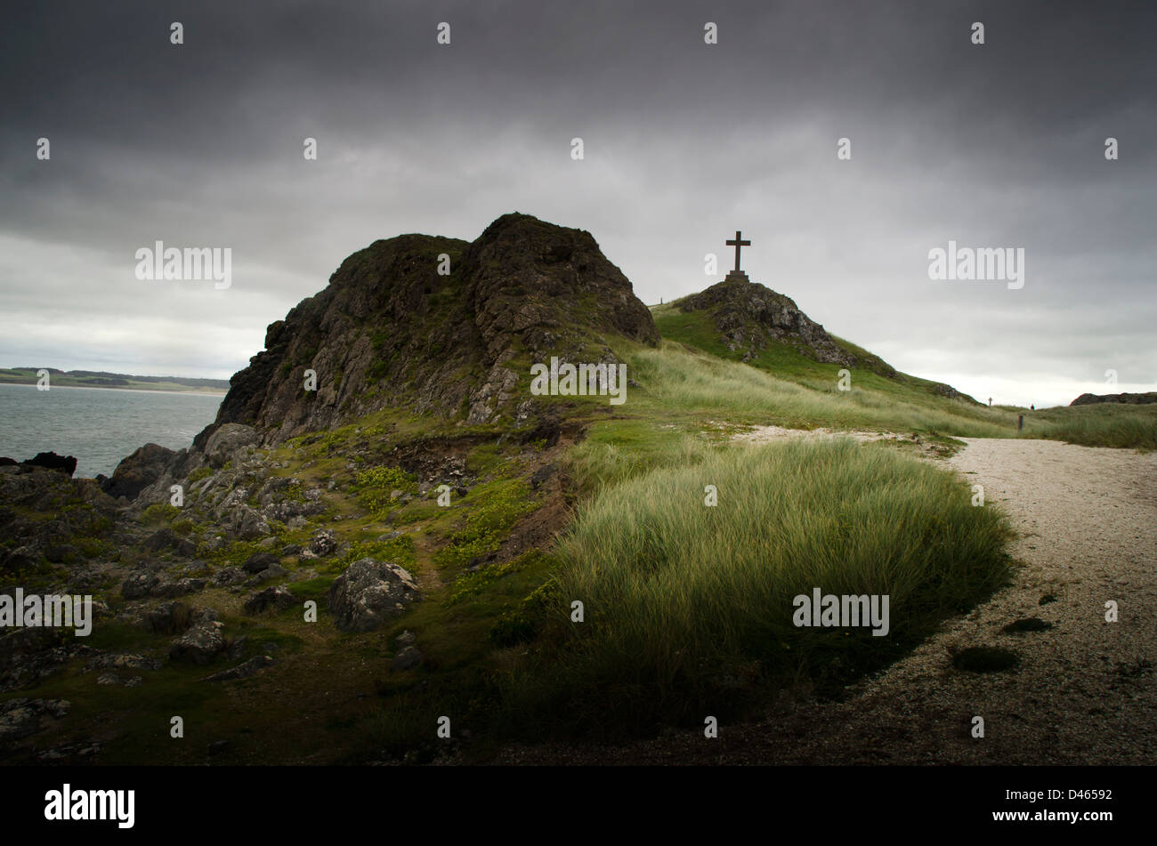 Kreuz auf einem Hügel in der Nähe von Meer, Denkmal, Religeon stürmischen Himmel, Spuk, Anglesey, North Wales, uk, Stockfoto