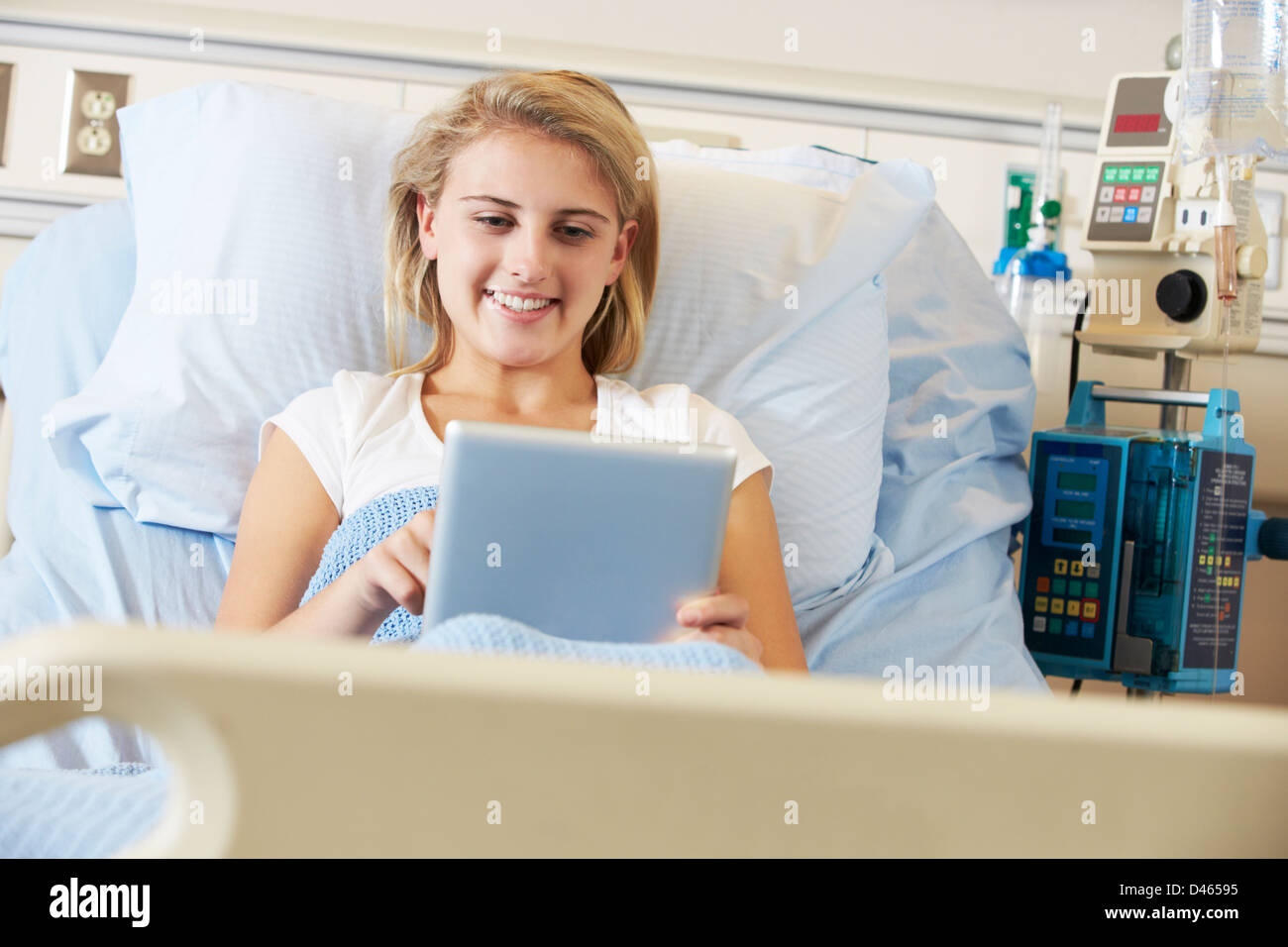 Teenager Patientin entspannend im Krankenhausbett mit Digital-Tablette Stockfoto