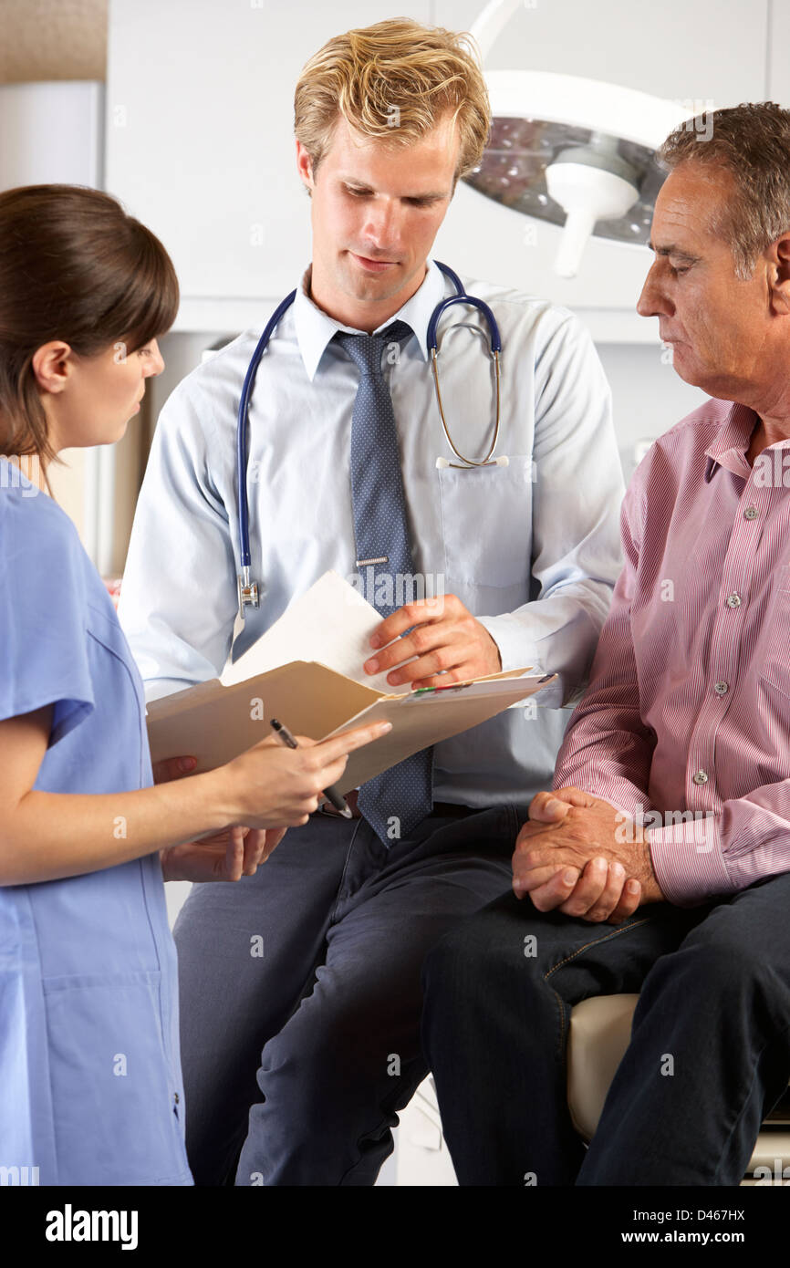 Männlicher Patient von Arzt und Intern geprüft Stockfoto