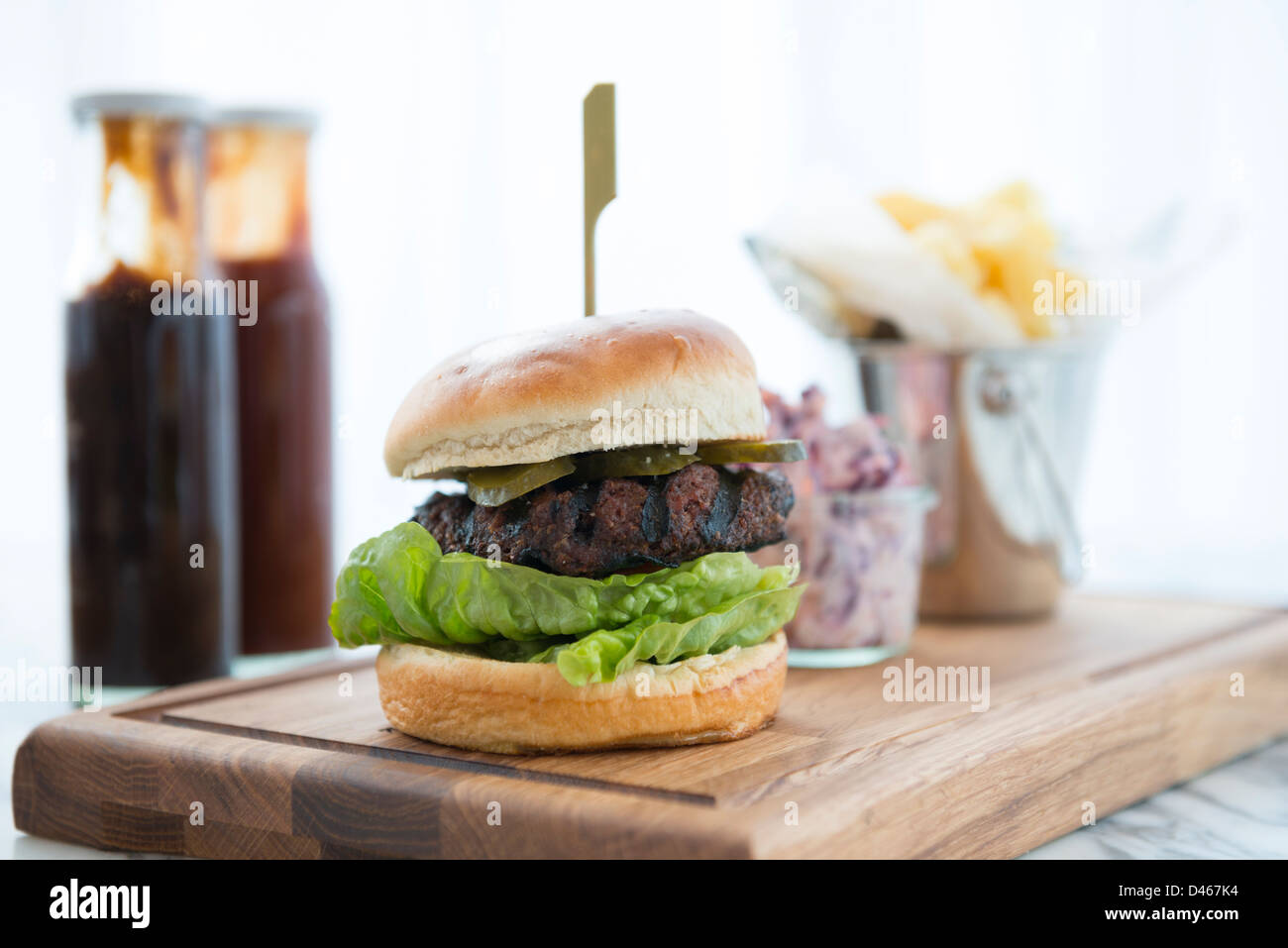 Beef-Burger in einem Brötchen, serviert mit Pommes frites Stockfoto