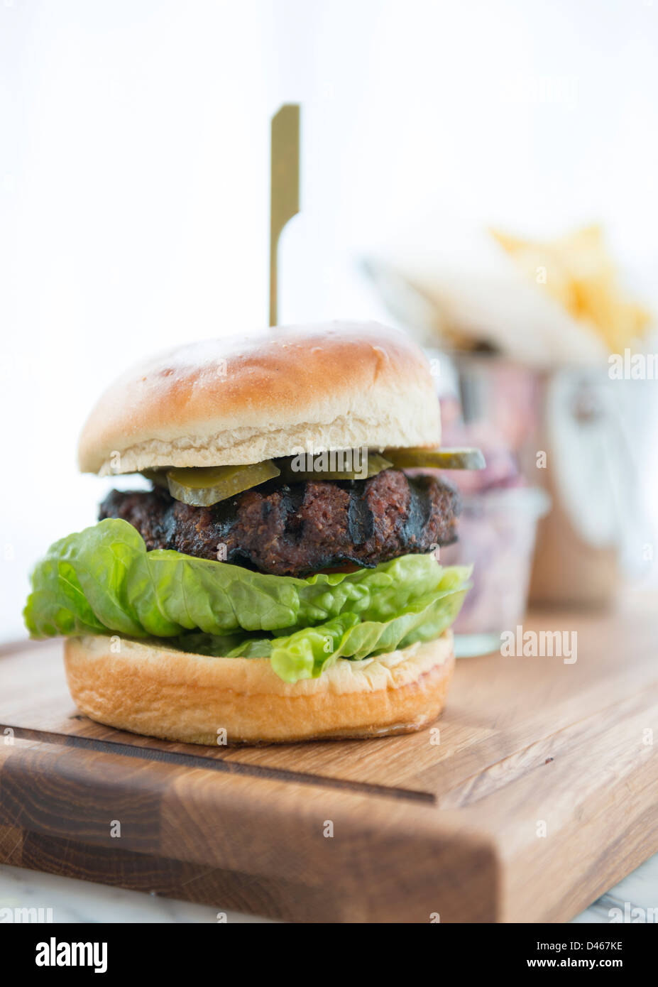 Beef-Burger in einem Brötchen, serviert mit Pommes frites Stockfoto
