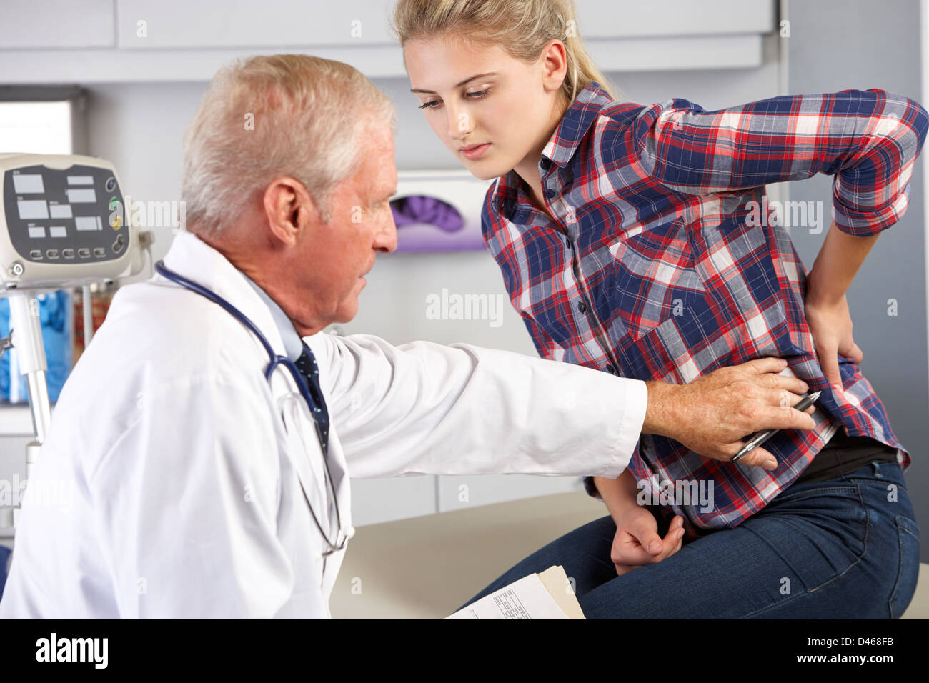 Teenager-Mädchen Besuche Arztpraxis mit Rückenschmerzen Stockfoto