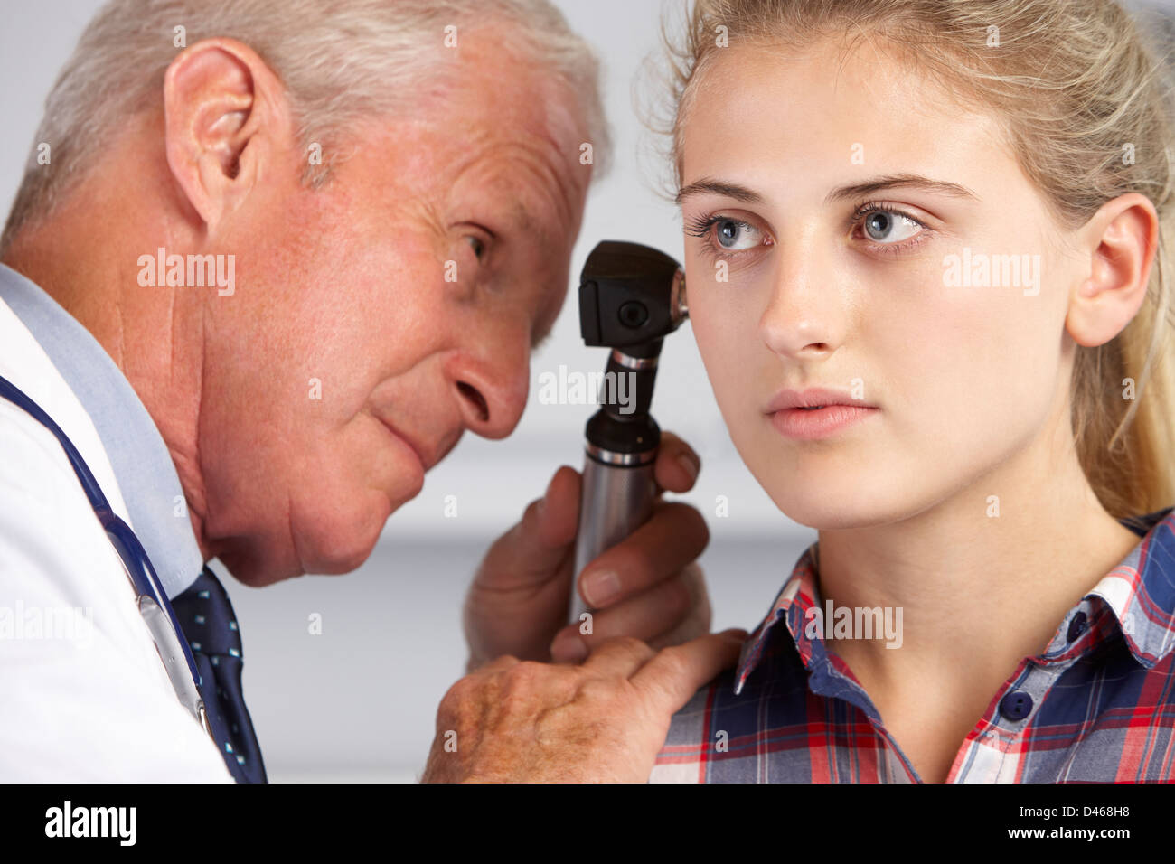 Arzt untersuchen Teenagerin Ohren Stockfoto