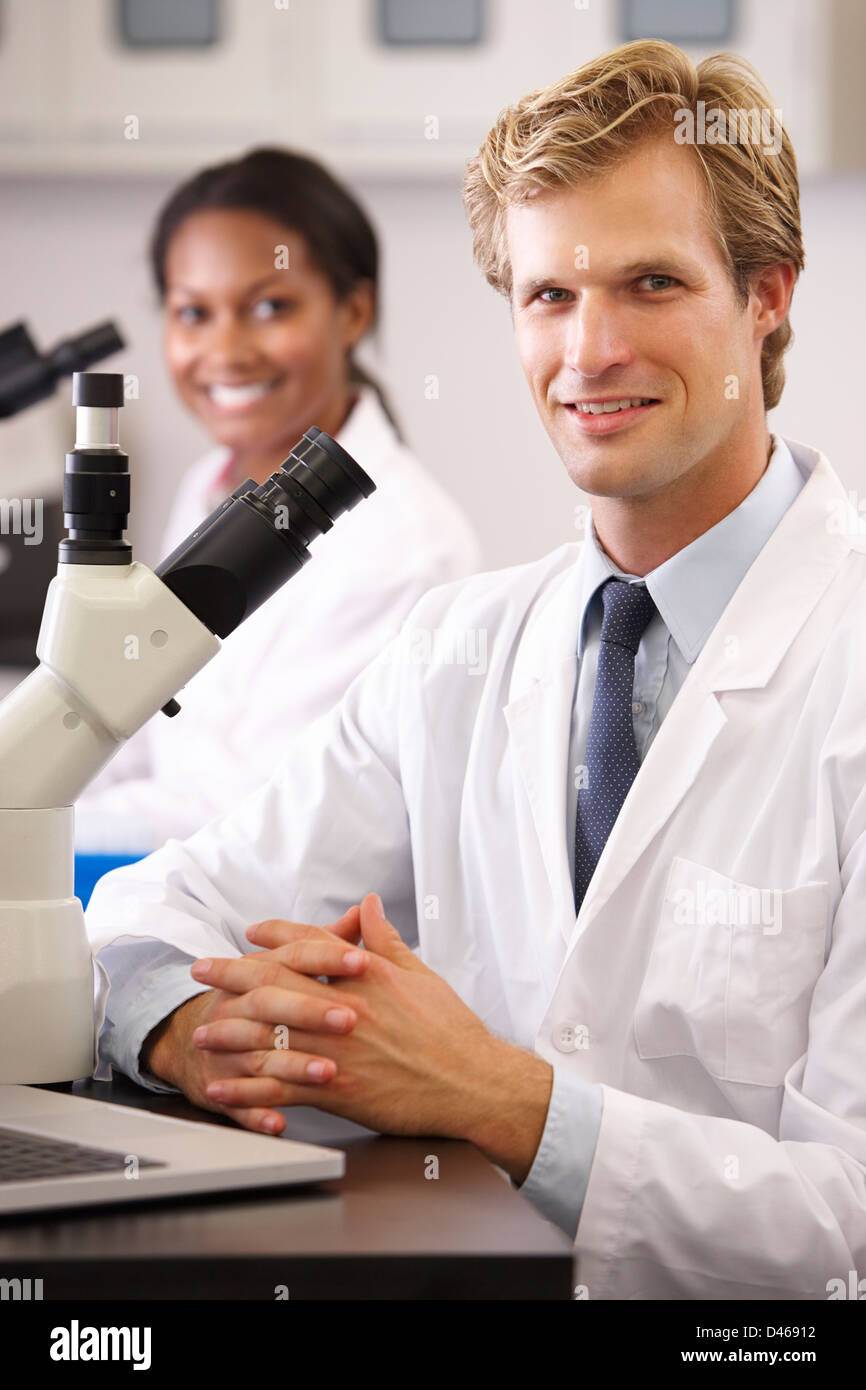 Männliche und weibliche Wissenschaftler Mikroskopie im Labor Stockfoto
