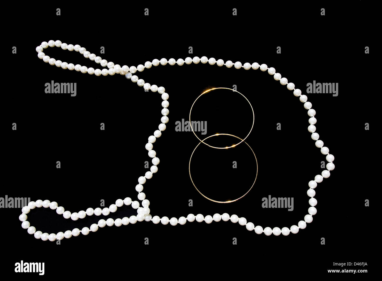 Eine Mode Perle Halskette über schwarzer Hintergrund mit zwei Handgelenk Ringe in die Mitte gelegt. Stockfoto