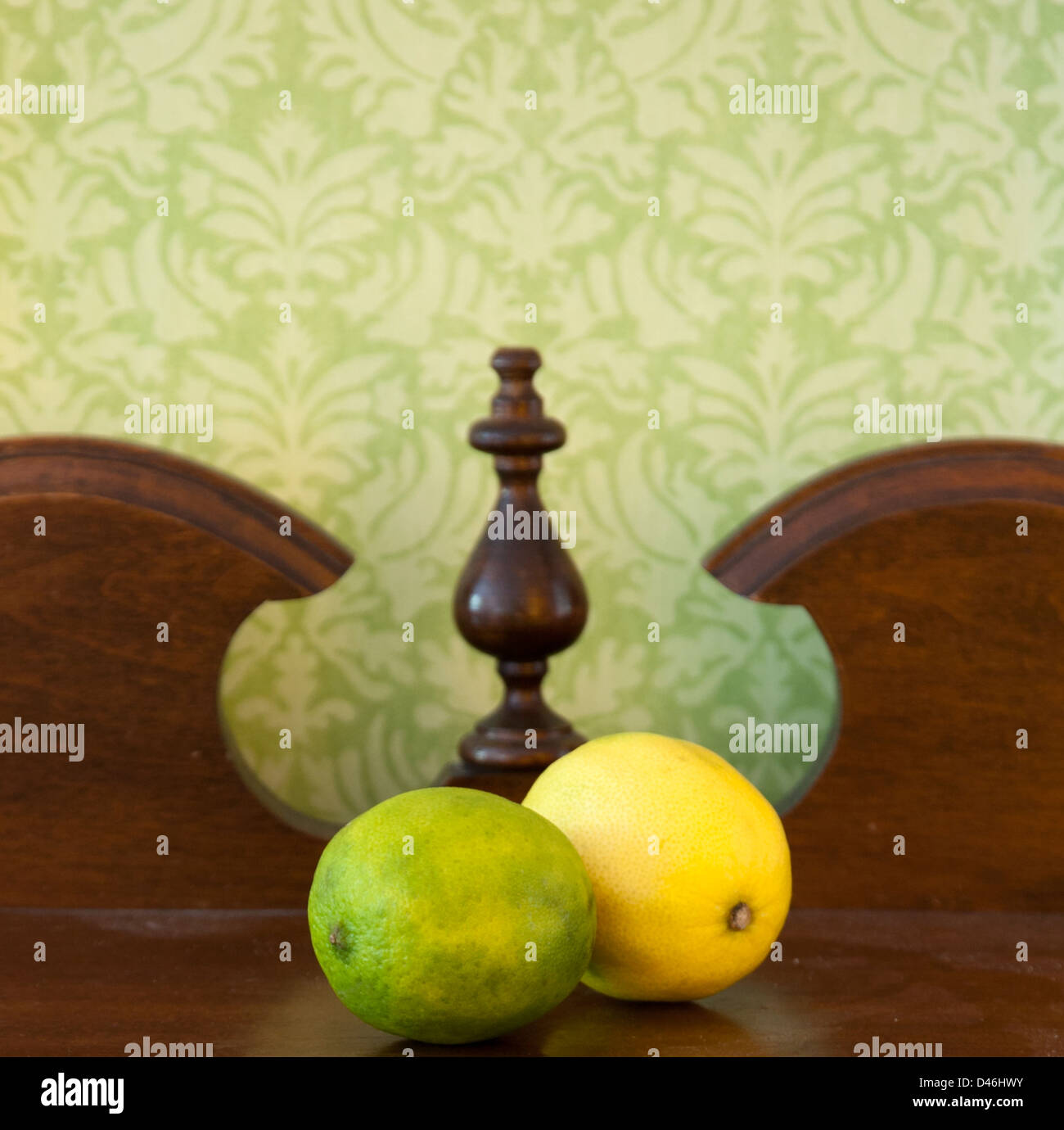 Zitrone und Limone auf alte Anrichte aus Holz in der Küche sitzen mit Vintage Tapete an Wand Stockfoto