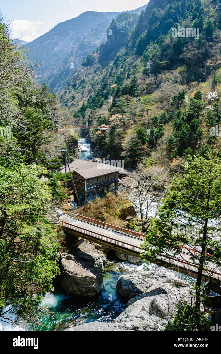 Steilen Tal mit Bach, Brücke und Gebäuden im ländlichen Kernland des Zentraljapan. Stockfoto