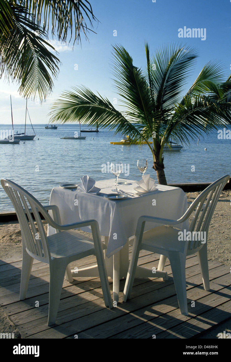 Ein Tisch für zwei erwartet die Gäste, die an den Rand des Wassers auf die private Little Palm Island Resort auf den Florida Keys in Florida, USA speisen wollen. Stockfoto