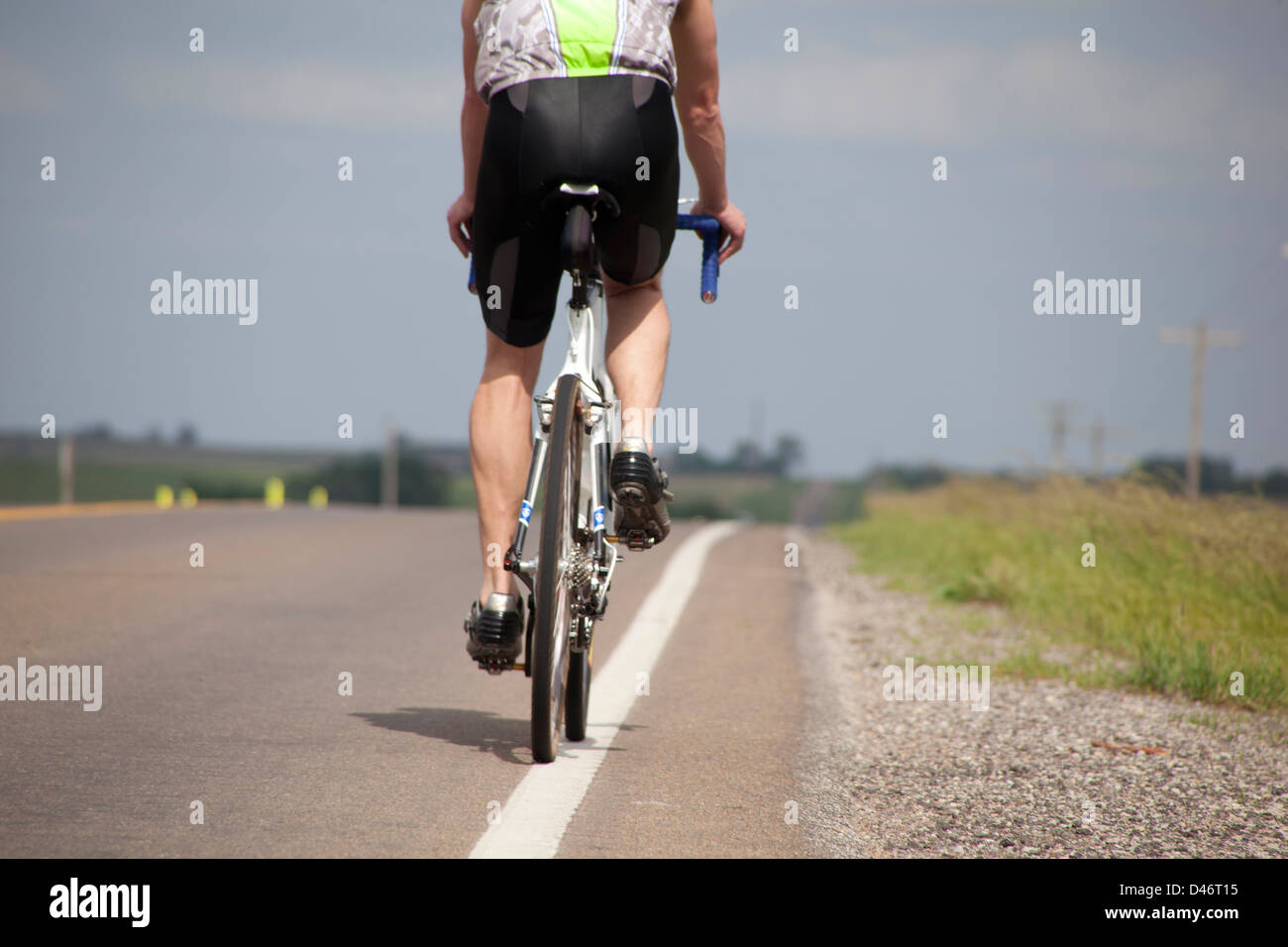 Radsportler, die auf einer einsamen Landstraße Stockfoto