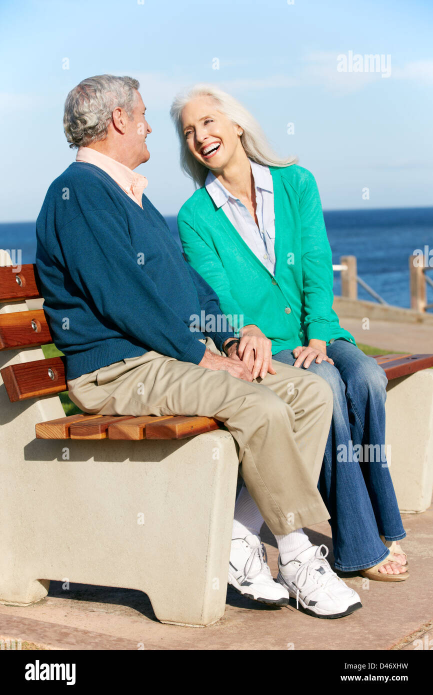 Älteres Paar auf Bank Meer beisammen sitzen Stockfoto
