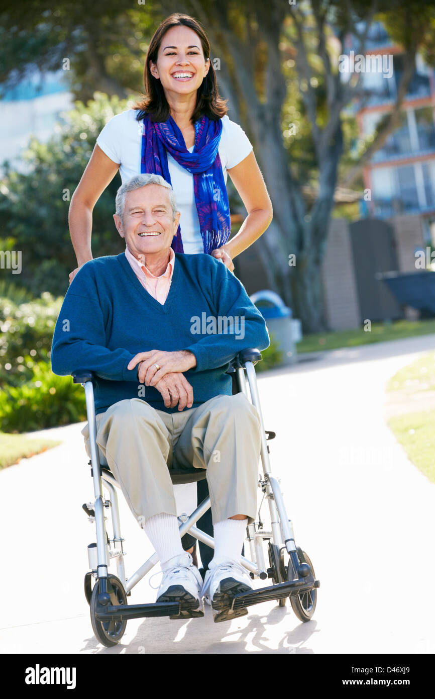 Erwachsene Tochter Senior Vater im Rollstuhl schieben Stockfoto