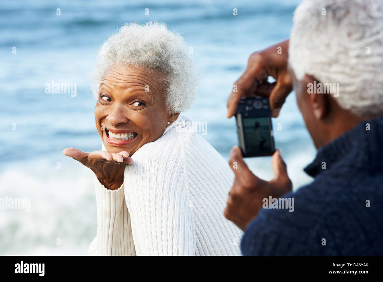 Älteres Paar mit Kamera am Strand Stockfoto
