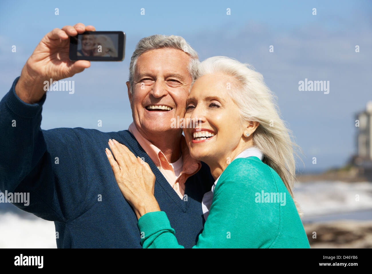 Älteres Paar mit Kamera am Strand Stockfoto