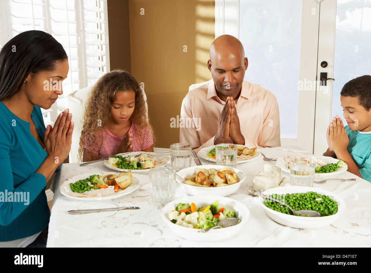 Familie sagen Gnade vor der Mahlzeit zu Hause Stockfoto