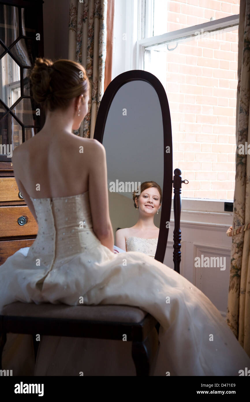 Rückseitige Ansicht spiegelt sich in ovalen Ganzkörperspiegel roten Haaren Braut in Creme strapless Brautkleid Stockfoto