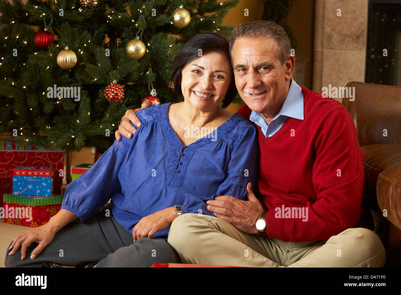 Älteres Paar vor Weihnachtsbaum Stockfoto