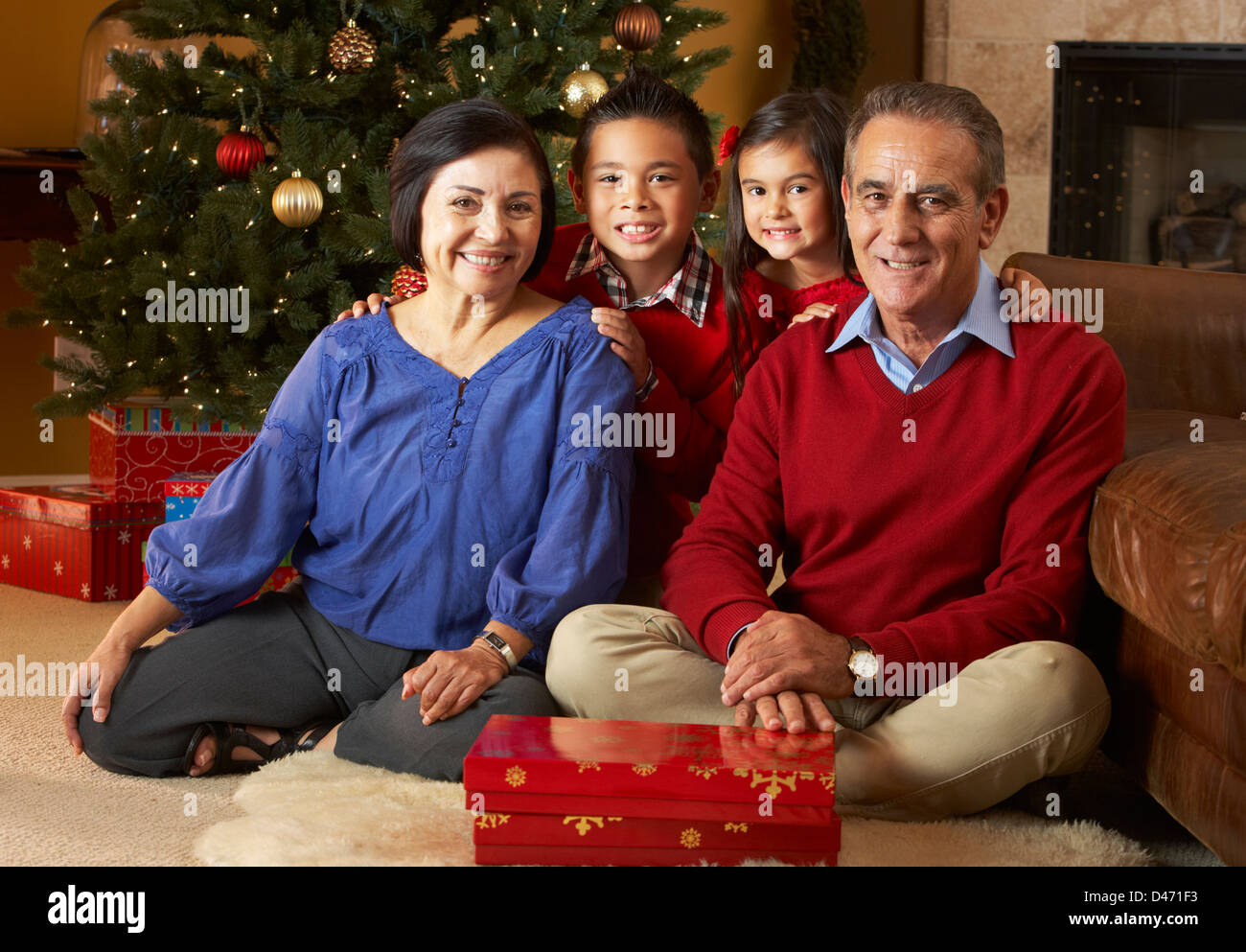 Großeltern mit Enkeln vor Weihnachtsbaum Stockfoto