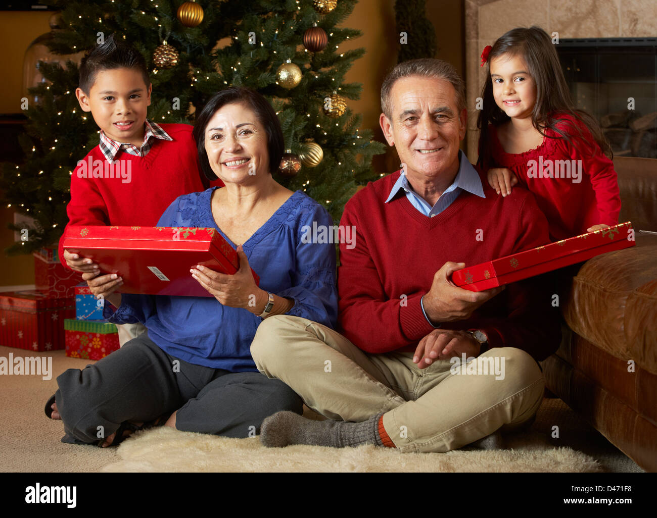 Großeltern mit Enkeln vor Weihnachtsbaum Stockfoto