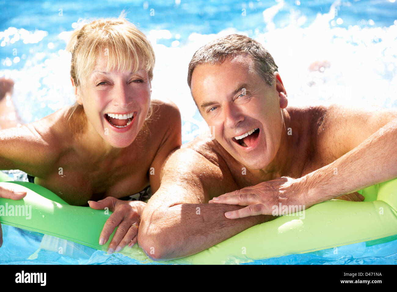 Ältere Paare, die Spaß im Schwimmbad Stockfoto