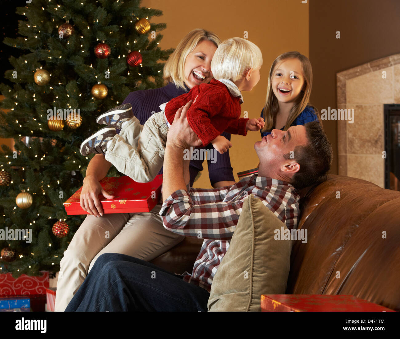 Familie Eröffnung präsentiert vor Weihnachtsbaum Stockfoto